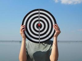 girl holding a dart board hiding face Business goals, goals that lead to success strategic planning ideas photo