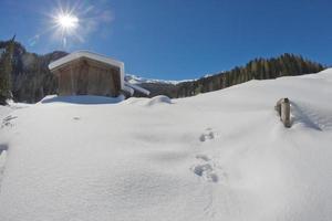 antigua cabaña de madera en el fondo de la nieve blanda foto