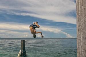 A young boy diving into the crystal water of Kapalai malaysia photo