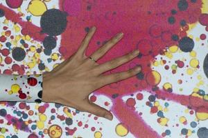 female hand on colour wall photo