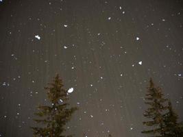 snowing at night in dolomites mountains photo