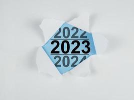 Rasgado papel con nuevo año texto 2023 en azul antecedentes. foto