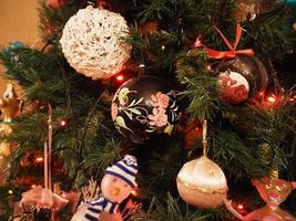 bola de navidad hecha a mano de vidrio en el detalle del árbol de navidad luces borrosas foto