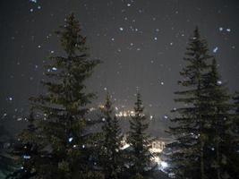 snowing at night in dolomites mountains photo