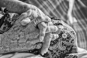 old retired woman crossed hands in black and white photo