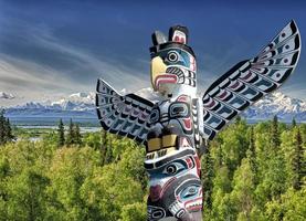 Totem wood pole in mountain background photo