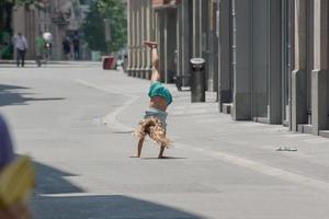 niño niña haciendo voltereta en el calle foto