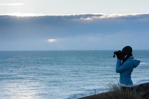 girl looking sea with binoculars photo