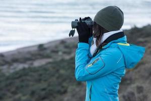 girl looking sea with binoculars photo