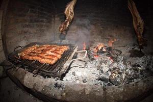 Asado cooking in ancient fireplace photo