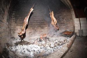 Asado cooking in ancient fireplace photo