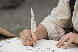 hands writing a letter with a plume photo