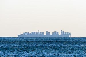 Big ship mirage on sea horizon line photo