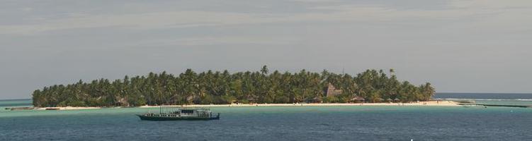 un pequeño isla recurso con un barco en Maldivas foto