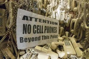 old cable telephones hanging from the wall photo