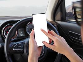 woman pressing on phone while driving photo