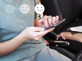 Young woman rating satisfaction with white icon, choose smiley face icon, very satisfied. photo