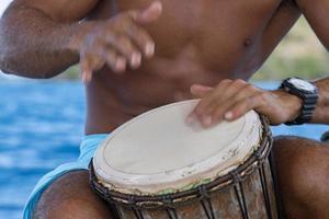 bora bora polynesian man playing drum on boat photo