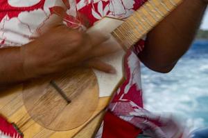 manos de anciano jugando hukulele en la polinesia francesa foto