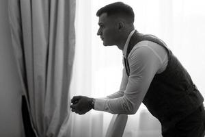 portrait of the groom in a light gray suit photo