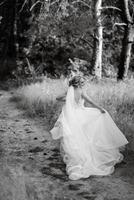 bride blonde girl with a bouquet in the forest photo