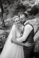 the groom and the bride are walking in the forest photo