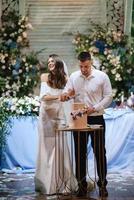 newlyweds happily cut and taste the wedding cake photo