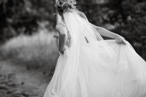 bride blonde girl with a bouquet in the forest photo