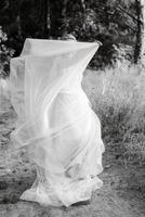 bride blonde girl with a bouquet in the forest photo