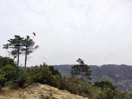 paraglider on cloudy sky in monterosso cinque terre italy photo