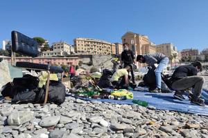 génova, italia - 28 de febrero de 2021 - jóvenes voluntarios recogen plástico y basura en la playa foto