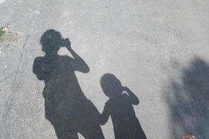 oscuridad de madre y niño en el asfalto foto