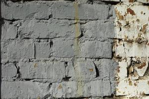 Grey wall. Painted bricks removed coarsely. Details of old building. photo