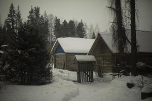 casa en pueblo en invierno. agricultura en bosque en nieve. techo en nieve. pequeño casa. foto