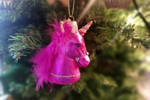 Unicorn glass hand made christmas ball on xmas tree detail blur lights photo