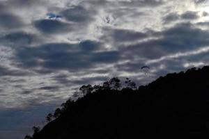 parapente en cielo nublado en monterosso cinque terre italia foto