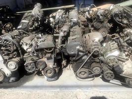 many old used car engine and parts photo