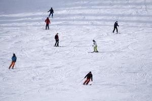 many skiers skiing in dolomites gardena valley snow mountains photo