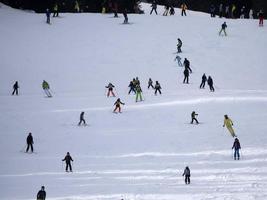 many skiers skiing in dolomites gardena valley snow mountains photo