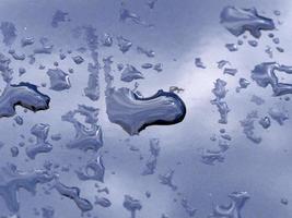 gotas de agua de lluvia en la superficie metálica azul foto