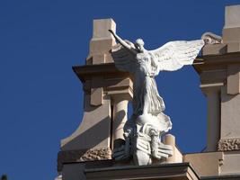 victory fascism angel statue on the top of old building photo