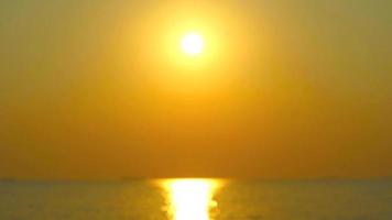 borrão ouro pôr do sol em a mar e brilhando reflexão do luz solar em a água superfície video
