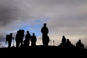 A group of trekkers black silhouette in the cloudy sky background photo
