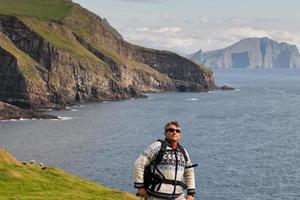 Toruist on faer oer mykines cliffs background photo