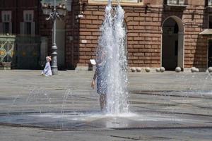 kid restoring inside funtain in hot summer photo