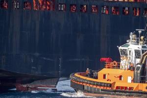 tug boat near big ship stern photo