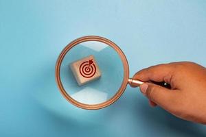 Magnifying glass with wooden block, target symbol.Work targeting concept. photo