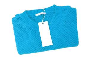 White blank rectangular clothing tag on turquoise knitted sweater isolated on white background photo