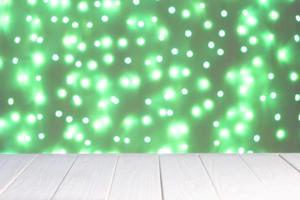 Abstract background, mockup. Defocused green lights bokeh and white wooden surface photo