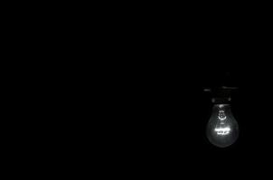 A light bulb over the black background photo
